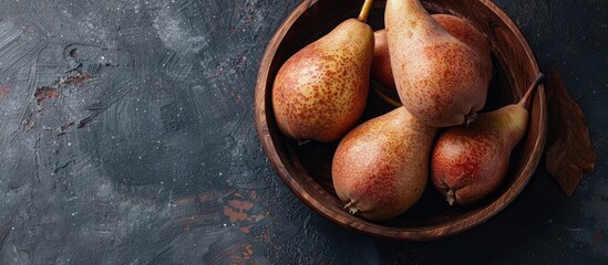 Aufkleber - A rustic style image portraying ripe brown pears in a wooden bowl against a dark background from a top view with copy space