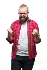 Sticker - Young caucasian hipster man wearing glasses over isolated background very happy and excited doing winner gesture with arms raised, smiling and screaming for success. Celebration concept.