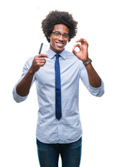 Wall Mural - afro american man holding credit card over isolated background doing ok sign with fingers, excellent