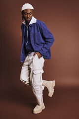 Wall Mural - A handsome young African American man wearing a blue jacket and white pants.