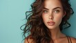 © Kanin - Stunning woman with wavy hair and blue eyes, posing against a turquoise background. Natural beauty and elegance in a close-up portrait.