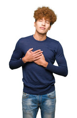 Wall Mural - Young handsome man with afro hair smiling with hands on chest with closed eyes and grateful gesture on face. Health concept.