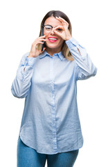 Wall Mural - Young beautiful business woman speaking calling using smartphone over isolated background with happy face smiling doing ok sign with hand on eye looking through fingers