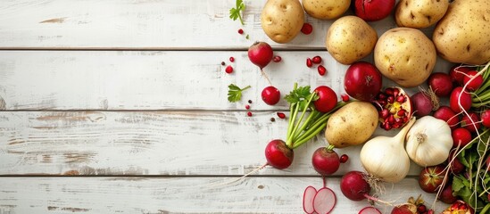 Aufkleber - Various fresh produce like potatoes onions radishes and fruits are displayed beautifully on a white wooden table in a flat lay arrangement offering ample copy space for a captivating image