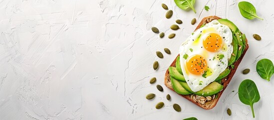 Canvas Print - Top down view of avocado toast adorned with egg and pumpkin seeds on a white background with space for text or graphics. with copy space image. Place for adding text or design