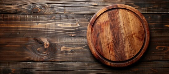Leinwandbilder - Top down view of an empty circular cutting board on a wooden surface with available space for text alongside the image. with copy space image. Place for adding text or design