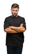 © Krakenimages.com - Young handsome man over isolated background skeptic and nervous, disapproving expression on face with crossed arms. Negative person.