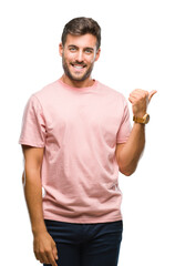 Sticker - Young handsome man over isolated background smiling with happy face looking and pointing to the side with thumb up.