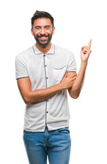 Sticker - Adult hispanic man over isolated background with a big smile on face, pointing with hand and finger to the side looking at the camera.