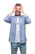 © Krakenimages.com - Young handsome man wearing white t-shirt over isolated background doing ok gesture like binoculars sticking tongue out, eyes looking through fingers. Crazy expression.
