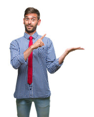 Canvas Print - Young handsome business man over isolated background amazed and smiling to the camera while presenting with hand and pointing with finger.