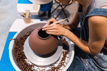 Beautiful young lady making ceramic pot on the pottery wheel . Concept for woman in freelance, business, hobby.