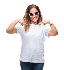 Canvas Print - Middle age hispanic woman wearing fashion sunglasses over isolated background looking confident with smile on face, pointing oneself with fingers proud and happy.