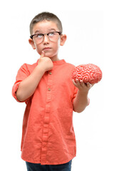 Sticker - Dark haired little child with glasses holding a brain serious face thinking about question, very confused idea