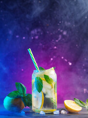 Wall Mural - refreshing summer mojito with lemon and mint. a cold summer cocktail . smoky colored light backgroun