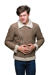 Sticker - Young handsome man wearing winter coat over isolated background with hand on stomach because indigestion, painful illness feeling unwell. Ache concept.