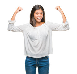 Poster - Young asian woman over isolated background showing arms muscles smiling proud. Fitness concept.