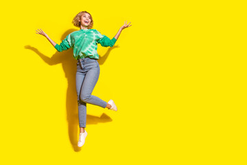 Canvas Print - Full length photo of cheerful pretty lady dressed green sweatshirt jumping high rising arms empty space isolated yellow color background