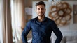 © Anastasiya - Serious young European man in a dark blue shirt with hands on hips, confident and determined expression, indoor setting, neutral background, horizontal image, copy space, defocus