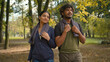 © Yuliia - Indian man with Arabian woman friends wife husband girl guy boyfriend girlfriend walking together after running workout sport training outdoors in forest park nature talking friendly communicating