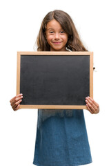 Canvas Print - Brunette hispanic girl holding blackboard with a happy face standing and smiling with a confident smile showing teeth