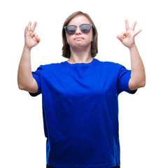 Sticker - Young adult woman with down syndrome wearing sunglasses over isolated background relax and smiling with eyes closed doing meditation gesture with fingers. Yoga concept.