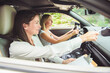 © Louis-Photo - driver courses and people concept a car driving school instructor teaching young woman to drive