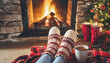 © netsay - Feet in woollen socks by the Christmas fireplace. Woman relaxes by warm fire with a cup of hot drink and warming up her feet in woollen socks. Close up on feet. Winter and Christmas holidays concept.