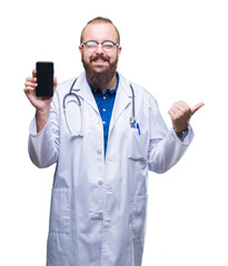 Wall Mural - Young doctor man showing smartphone screen over isolated background pointing and showing with thumb up to the side with happy face smiling