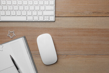 Wall Mural - Wireless mouse, notebook, pen and computer keyboard on wooden table, flat lay. Space for text