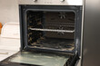 © New Africa - Open electric oven covered with cleaning foam in kitchen