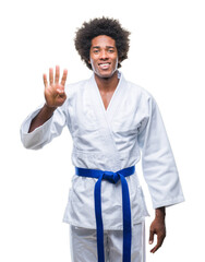 Sticker - Afro american man wearing karate kimono over isolated background showing and pointing up with fingers number four while smiling confident and happy.