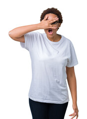 Wall Mural - Beautiful young african american woman wearing glasses over isolated background peeking in shock covering face and eyes with hand, looking through fingers with embarrassed expression.