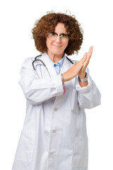 Poster - Middle ager senior doctor woman over isolated background Clapping and applauding happy and joyful, smiling proud hands together