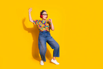 Wall Mural - Full body portrait of nice aged lady dance sing headphones wear t-shirt isolated on yellow color background