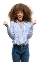 Wall Mural - African american woman wearing a stripes shirt screaming proud and celebrating victory and success very excited, cheering emotion