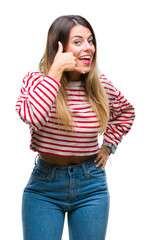 Poster - Young beautiful woman casual stripes winter sweater over isolated background smiling doing phone gesture with hand and fingers like talking on the telephone. Communicating concepts.