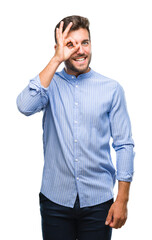 Canvas Print - Young handsome man over isolated background doing ok gesture with hand smiling, eye looking through fingers with happy face.