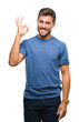 © Krakenimages.com - Young handsome man over isolated background smiling positive doing ok sign with hand and fingers. Successful expression.
