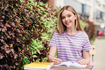 Poster - Photo of adorable sweet lady wear striped t-shirt sitting cafeteria writing copybook outdoors urban city street