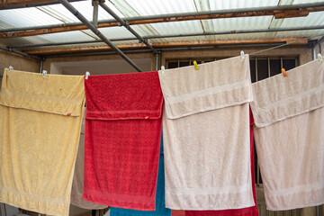 Colorful towels hang on a wire, drying in the breeze after being freshly washed, adding a vibrant touch to the outdoors.