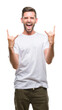 © Krakenimages.com - Young handsome man over isolated background shouting with crazy expression doing rock symbol with hands up. Music star. Heavy concept.