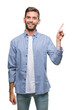 © Krakenimages.com - Young handsome man wearing white t-shirt over isolated background with a big smile on face, pointing with hand and finger to the side looking at the camera.
