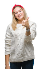 Poster - Young caucasian woman wearing winter sweater over isolated background doing happy thumbs up gesture with hand. Approving expression looking at the camera with showing success.