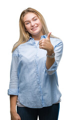 Poster - Young caucasian business woman over isolated background doing happy thumbs up gesture with hand. Approving expression looking at the camera with showing success.