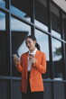 © Sutthicha - Portrait of a successful business woman using digital tablet in front of modern business building