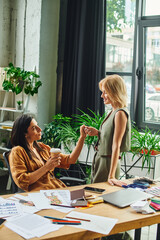 lesbian couple, dressed in smart casual attire, collaborate on a project in a modern agency office.