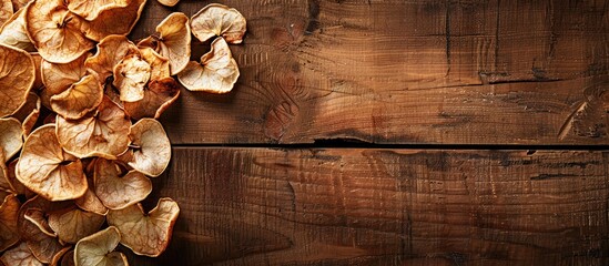 Wall Mural - A wooden surface serves as a backdrop for dried apple chips neatly arranged for a copy space image