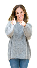 Wall Mural - Beautiful middle age woman wearing winter sweater over isolated background Pointing to you and the camera with fingers, smiling positive and cheerful