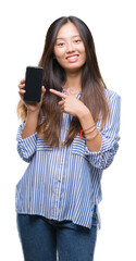 Canvas Print - Young asian woman showing blank screen of smartphone over isolated background very happy pointing with hand and finger